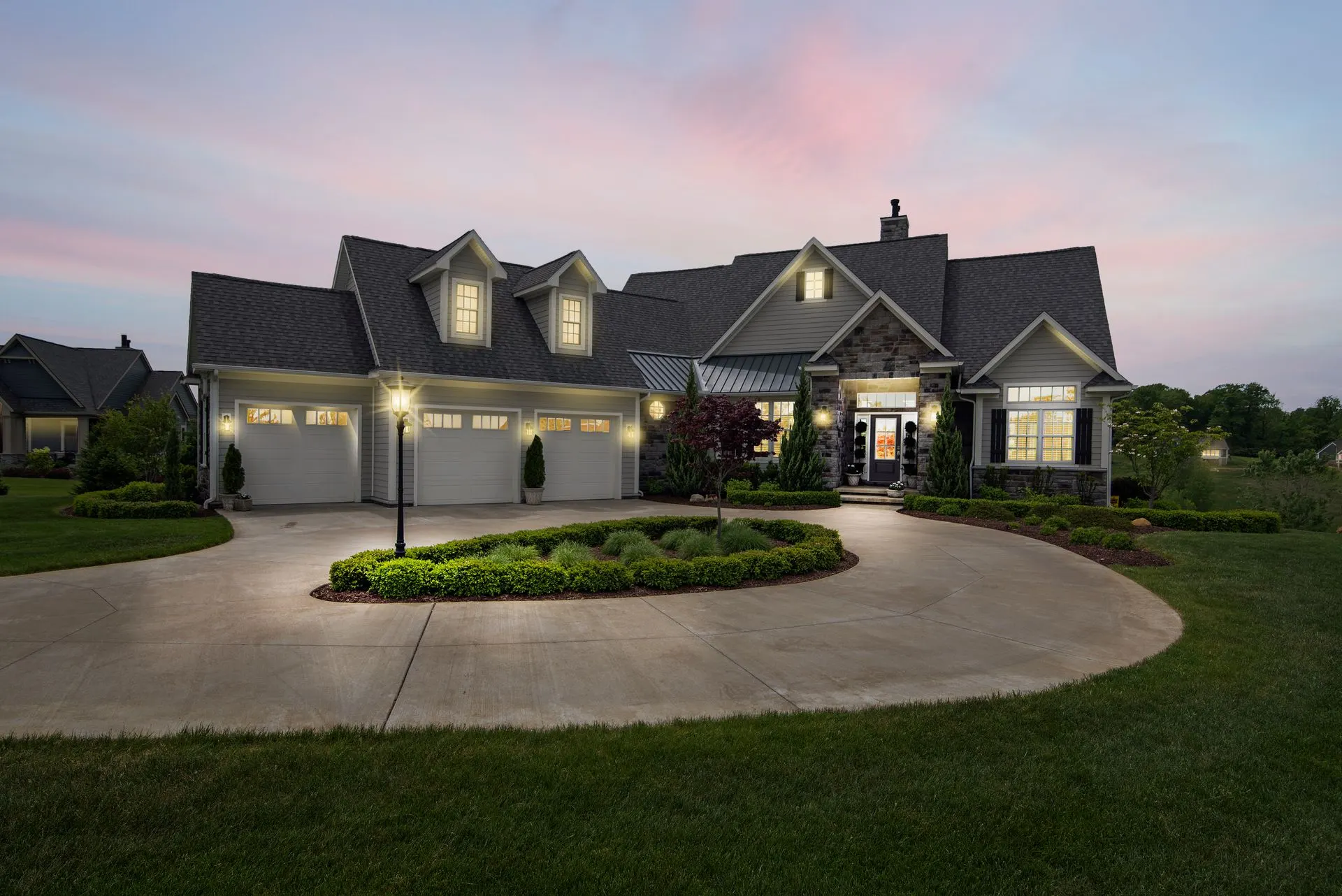 Two-story home at dusk with exterior lighting