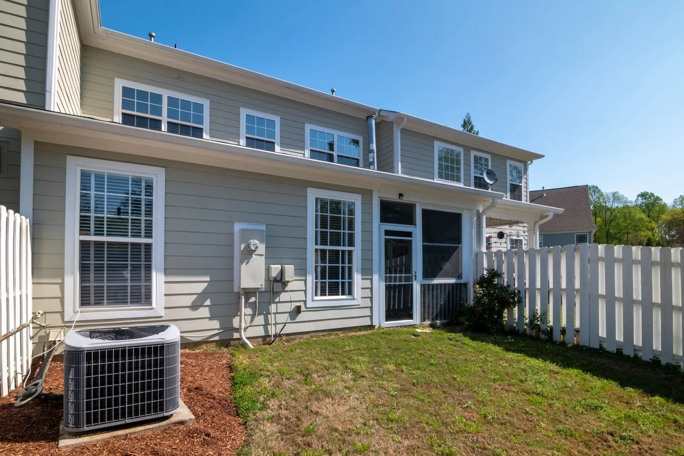 Backyard of a home with a central AC condenser