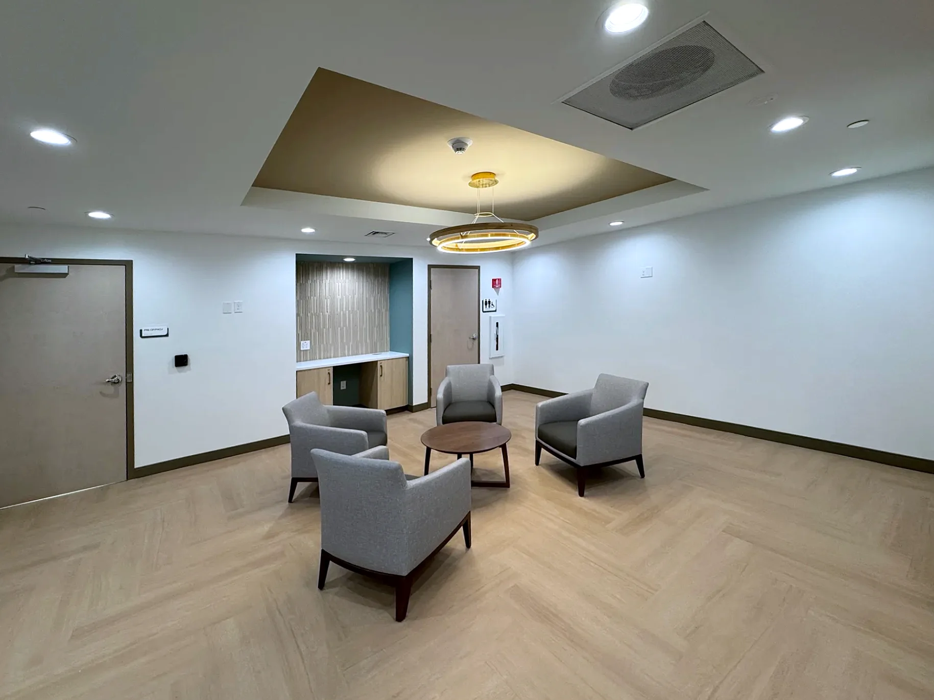 Family lounge with LED ring pendant and recessed lighting by Texas A&E