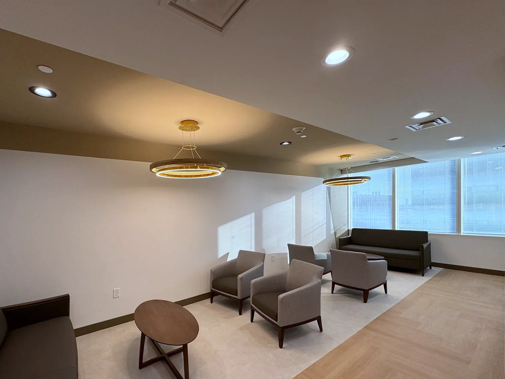 Healthcare waiting room lighting: LED ring pendants and recessed downlights installed by Texas A&E